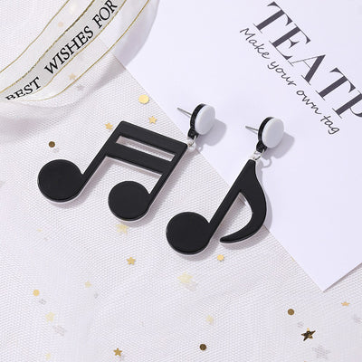 Retro Revival Notable Notes Earrings - Large asymmetrical acrylic earrings shaped like oversized musical notes, created from stylized pink, white, or black acrylic.