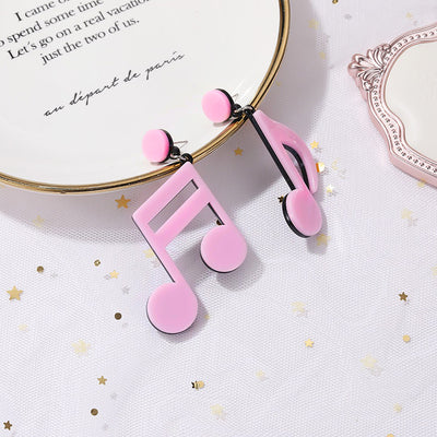 Retro Revival Notable Notes Earrings - Large asymmetrical acrylic earrings shaped like oversized musical notes, created from stylized pink, white, or black acrylic.