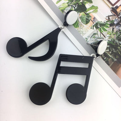 Retro Revival Notable Notes Earrings - Large asymmetrical acrylic earrings shaped like oversized musical notes, created from stylized pink, white, or black acrylic.