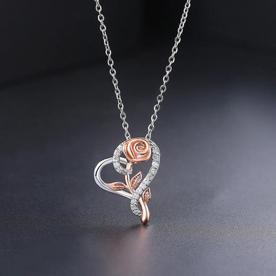 Rosalie Rosebud Heart Necklace - An elegant floral-themed necklace featuring a platinum plated heart with a beautiful rose gold rose, and sparkling crystals.