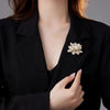 Sadira Crystal Lotus Brooch - An elegant flower brooch featuring an array of jewel-encrusted petals surrounding a central pearl.