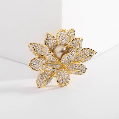 Sadira Crystal Lotus Brooch - An elegant flower brooch featuring an array of jewel-encrusted petals surrounding a central pearl.