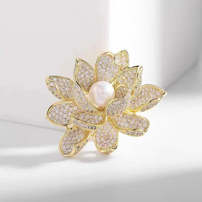 Sadira Crystal Lotus Brooch - An elegant flower brooch featuring an array of jewel-encrusted petals surrounding a central pearl.