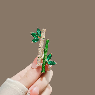Sasae Crystal Bamboo Brooch - An elegant green brooch designed to look like a pair of stylised bamboo stalks, adorned with green and white crystals.