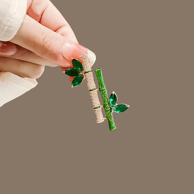 Sasae Crystal Bamboo Brooch - An elegant green brooch designed to look like a pair of stylised bamboo stalks, adorned with green and white crystals.