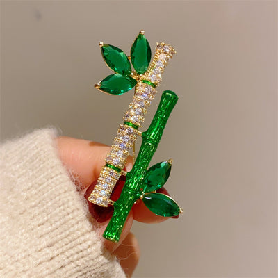 Sasae Crystal Bamboo Brooch - An elegant green brooch designed to look like a pair of stylised bamboo stalks, adorned with green and white crystals.