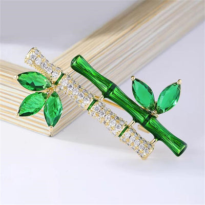 Sasae Crystal Bamboo Brooch - An elegant green brooch designed to look like a pair of stylised bamboo stalks, adorned with green and white crystals.