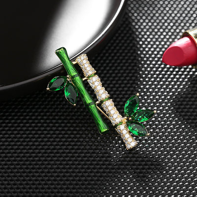 Sasae Crystal Bamboo Brooch - An elegant green brooch designed to look like a pair of stylised bamboo stalks, adorned with green and white crystals.