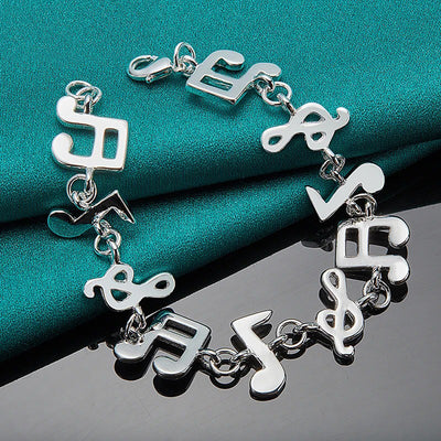 Shania Music Note Charm Bracelet - A lovely sterling silver brooch featuring a combination of stylised music notes strung together end to end.