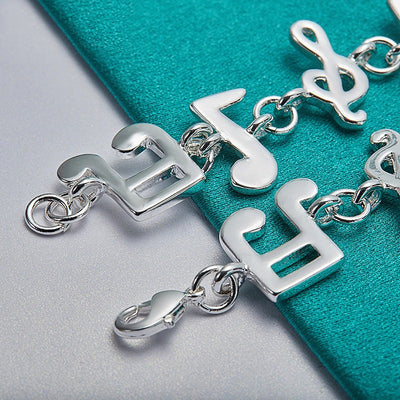 Shania Music Note Charm Bracelet - A lovely sterling silver brooch featuring a combination of stylised music notes strung together end to end.