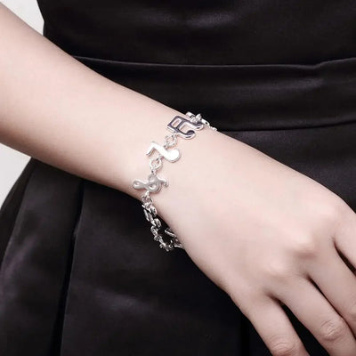 Shania Music Note Charm Bracelet - A lovely sterling silver brooch featuring a combination of stylised music notes strung together end to end.