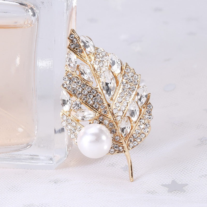 Sian Crystal Leaf Brooch - A medium-sized brooch shaped like a leaf, studded with assorted round and marquise cut crystals, and a pearl. 