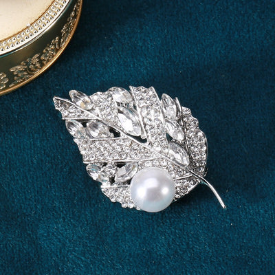 Sian Crystal Leaf Brooch - A medium-sized brooch shaped like a leaf, studded with assorted round and marquise cut crystals, and a pearl.