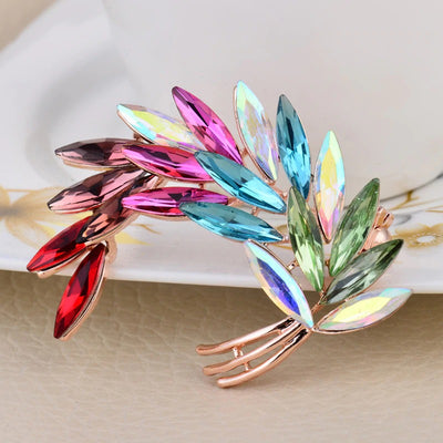 Sitaria Crystal Curved Grain Brooch - An elegant crystal brooch crafted from an assortment of marquise cut crystals arranged to look like heads of grain, in either a golden champagne colour or a rainbow gradient.