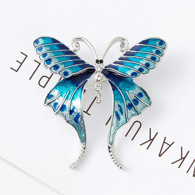 Skylar Long-Tail Butterfly Brooch - A lovely medium-sized butterfly brooch featuring colourful enamel and shiny artificial crystals. Available in your choice of blues or purple and green.