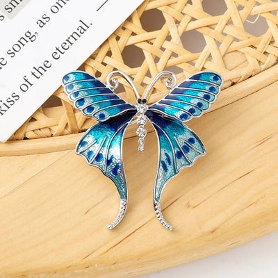 Skylar Long-Tail Butterfly Brooch - A lovely medium-sized butterfly brooch featuring colourful enamel and shiny artificial crystals. Available in your choice of blues or purple and green.