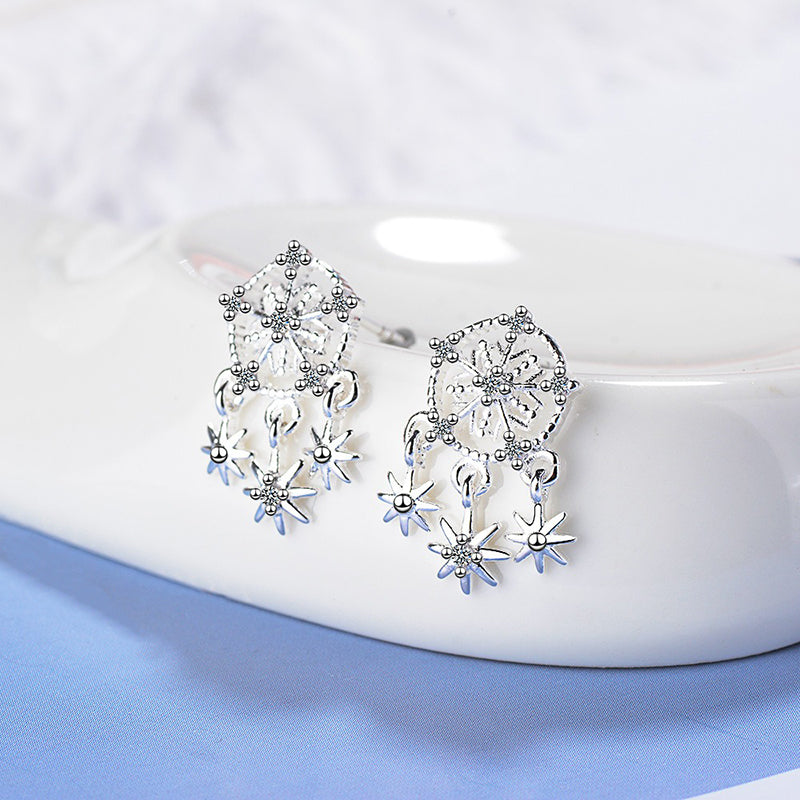 Snowflake Dreams Earrings - Tiny sterling silver earring shaped like little snowflakes, with other snowflakes dangling off it. 