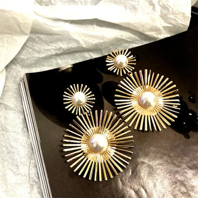 Solaris Radiant Statement Earrings - Large statement earrings featuring a round starburst shape with long rays radiating out from a central pearl.