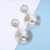 Solaris Radiant Statement Earrings - Large statement earrings featuring a round starburst shape with long rays radiating out from a central pearl.