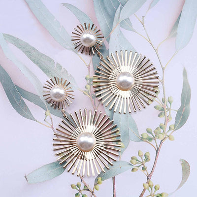 Solaris Radiant Statement Earrings - Large statement earrings featuring a round starburst shape with long rays radiating out from a central pearl.