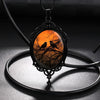 Sunset Ravens Cameo Necklace - A large gothic glass cabochon featuring an image of two silhouetted ravens or crows against a vibrant orange background.