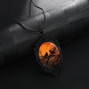 Sunset Ravens Cameo Necklace - A large gothic glass cabochon featuring an image of two silhouetted ravens or crows against a vibrant orange background.