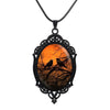 Sunset Ravens Cameo Necklace - A large gothic glass cabochon featuring an image of two silhouetted ravens or crows against a vibrant orange background.