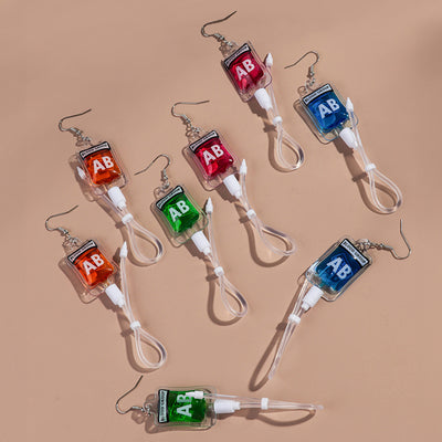 Teenytopia Alien Nurse Blood Bag - Cute, stylish Halloween earrings featuring a tiny bag of strangely-coloured blood and cables suspended from a French hook.