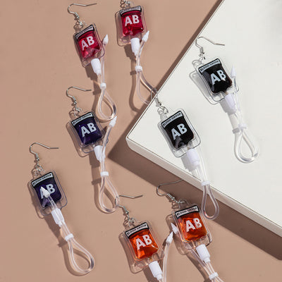 Teenytopia Alien Nurse Blood Bag - Cute, stylish Halloween earrings featuring a tiny bag of strangely-coloured blood and cables suspended from a French hook.