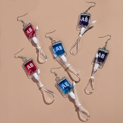 Teenytopia Alien Nurse Blood Bag - Cute, stylish Halloween earrings featuring a tiny bag of strangely-coloured blood and cables suspended from a French hook.