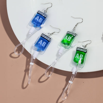 Teenytopia Alien Nurse Blood Bag - Cute, stylish Halloween earrings featuring a tiny bag of strangely-coloured blood and cables suspended from a French hook.