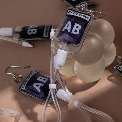 Teenytopia Alien Nurse Blood Bag - Cute, stylish Halloween earrings featuring a tiny bag of strangely-coloured blood and cables suspended from a French hook.