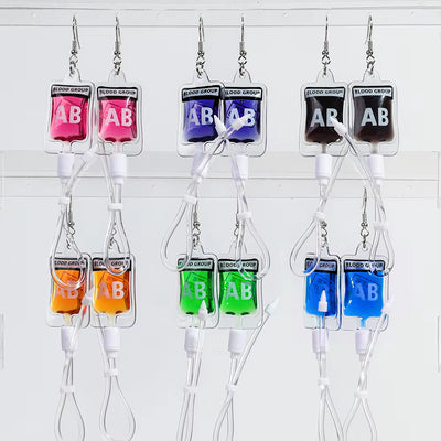 Teenytopia Alien Nurse Blood Bag - Cute, stylish Halloween earrings featuring a tiny bag of strangely-coloured blood and cables suspended from a French hook.