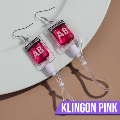 Teenytopia Alien Nurse Blood Bag - Cute, stylish Halloween earrings featuring a tiny bag of strangely-coloured blood and cables suspended from a French hook.