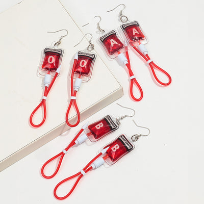 Teenytopia Naughty Nurse Blood Bag Earrings - Cute, stylish Halloween earrings featuring a tiny bag of blood and cables suspended from a French hook.