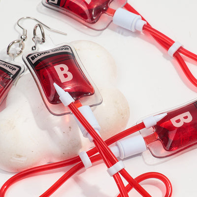 Teenytopia Naughty Nurse Blood Bag Earrings - Cute, stylish Halloween earrings featuring a tiny bag of blood and cables suspended from a French hook.