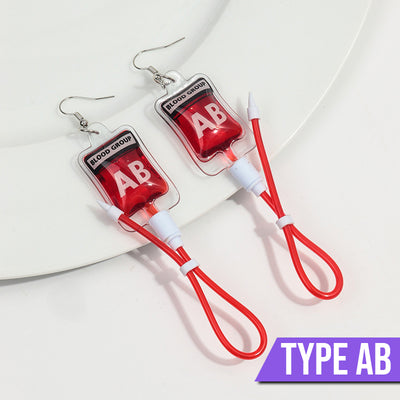 Teenytopia Naughty Nurse Blood Bag Earrings - Cute, stylish Halloween earrings featuring a tiny bag of blood and cables suspended from a French hook.