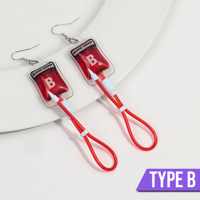Teenytopia Naughty Nurse Blood Bag Earrings - Cute, stylish Halloween earrings featuring a tiny bag of blood and cables suspended from a French hook.