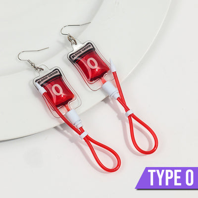 Teenytopia Naughty Nurse Blood Bag Earrings - Cute, stylish Halloween earrings featuring a tiny bag of blood and cables suspended from a French hook.