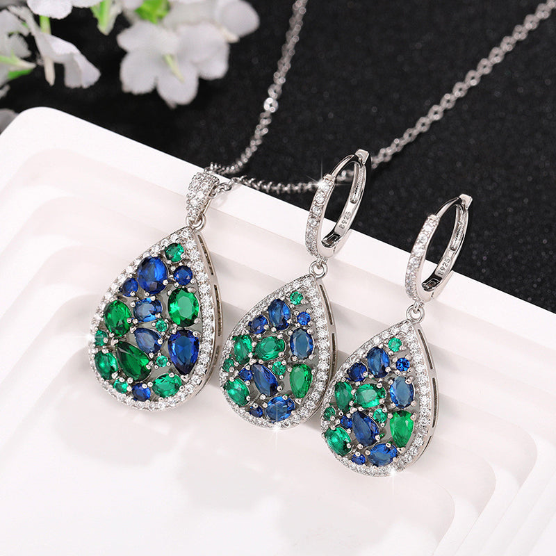 Terra Earth & Sky Crystal Drop Pendant & Earrings Set - An elegant teardrop-shaped pendant and earrings featuring a mixture of green and dark blue crystals, trimmed with delicate white crystals.