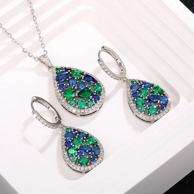 Terra Earth & Sky Crystal Drop Pendant & Earrings Set - An elegant teardrop-shaped pendant and earrings featuring a mixture of green and dark blue crystals, trimmed with delicate white crystals.