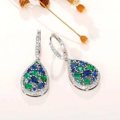 Terra Earth & Sky Crystal Drop Pendant & Earrings Set - An elegant teardrop-shaped pendant and earrings featuring a mixture of green and dark blue crystals, trimmed with delicate white crystals.