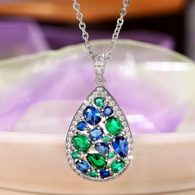 Terra Earth & Sky Crystal Drop Pendant & Earrings Set - An elegant teardrop-shaped pendant and earrings featuring a mixture of green and dark blue crystals, trimmed with delicate white crystals.