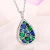 Terra Earth & Sky Crystal Drop Pendant & Earrings Set - An elegant teardrop-shaped pendant and earrings featuring a mixture of green and dark blue crystals, trimmed with delicate white crystals.