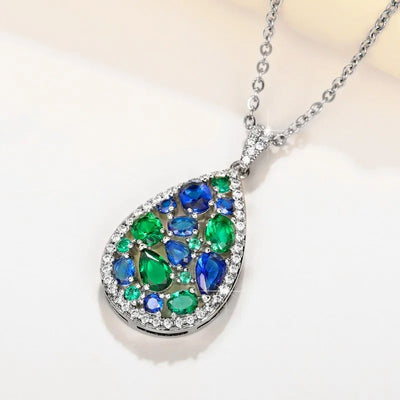 Terra Earth & Sky Crystal Drop Pendant & Earrings Set - An elegant teardrop-shaped pendant and earrings featuring a mixture of green and dark blue crystals, trimmed with delicate white crystals.