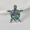 The Tropicana Honu Turtle Brooch - A beautiful silver-toned zinc alloy turtle brooch adorned with crystals and polished paua shell.