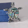 The Tropicana Honu Turtle Brooch - A beautiful silver-toned zinc alloy turtle brooch adorned with crystals and polished paua shell.