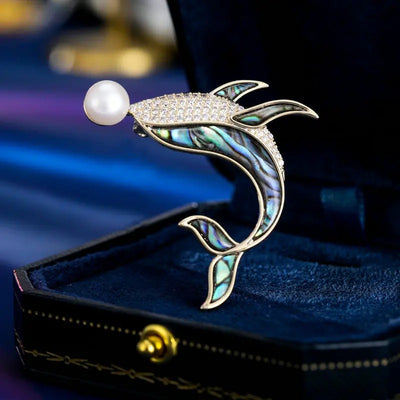 The Tropicana Kohola Whale Brooch - A beautiful gold-toned zinc alloy whale brooch adorned with polished paua shell and an artificial pearl.