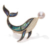 The Tropicana Kohola Whale Brooch - A beautiful gold-toned zinc alloy whale brooch adorned with polished paua shell and an artificial pearl.