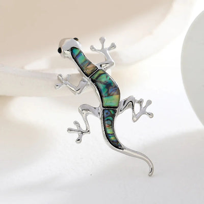 Tropicana Mo'o Gecko Brooch - A stylised silver-toned zinc alloy gecko brooch adorned with polished paua shell and artificial crystals.